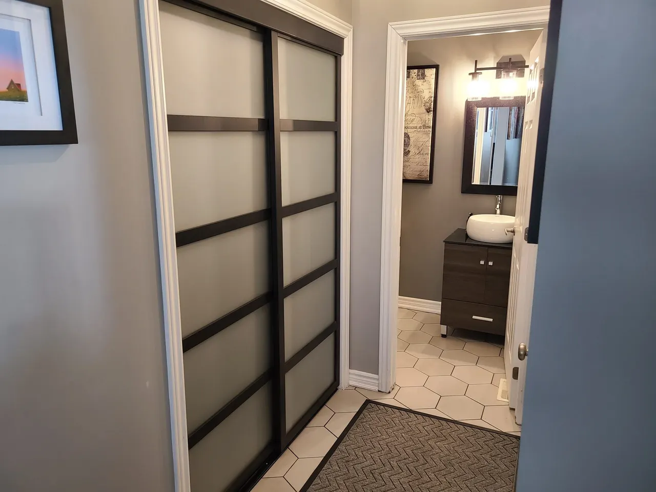 Hallway storage with hexagon-tile powder room in Almonte by ALM Construction