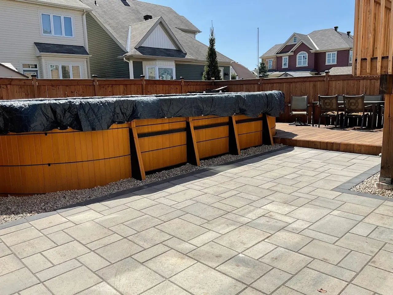 Full backyard landscape construction with paver patio, hot-tub surround and integrated deck by ALM Construction Ottawa
